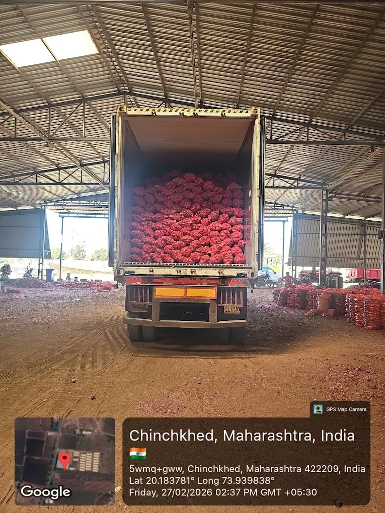 A truck loaded with red produce sacks at a supplier facility